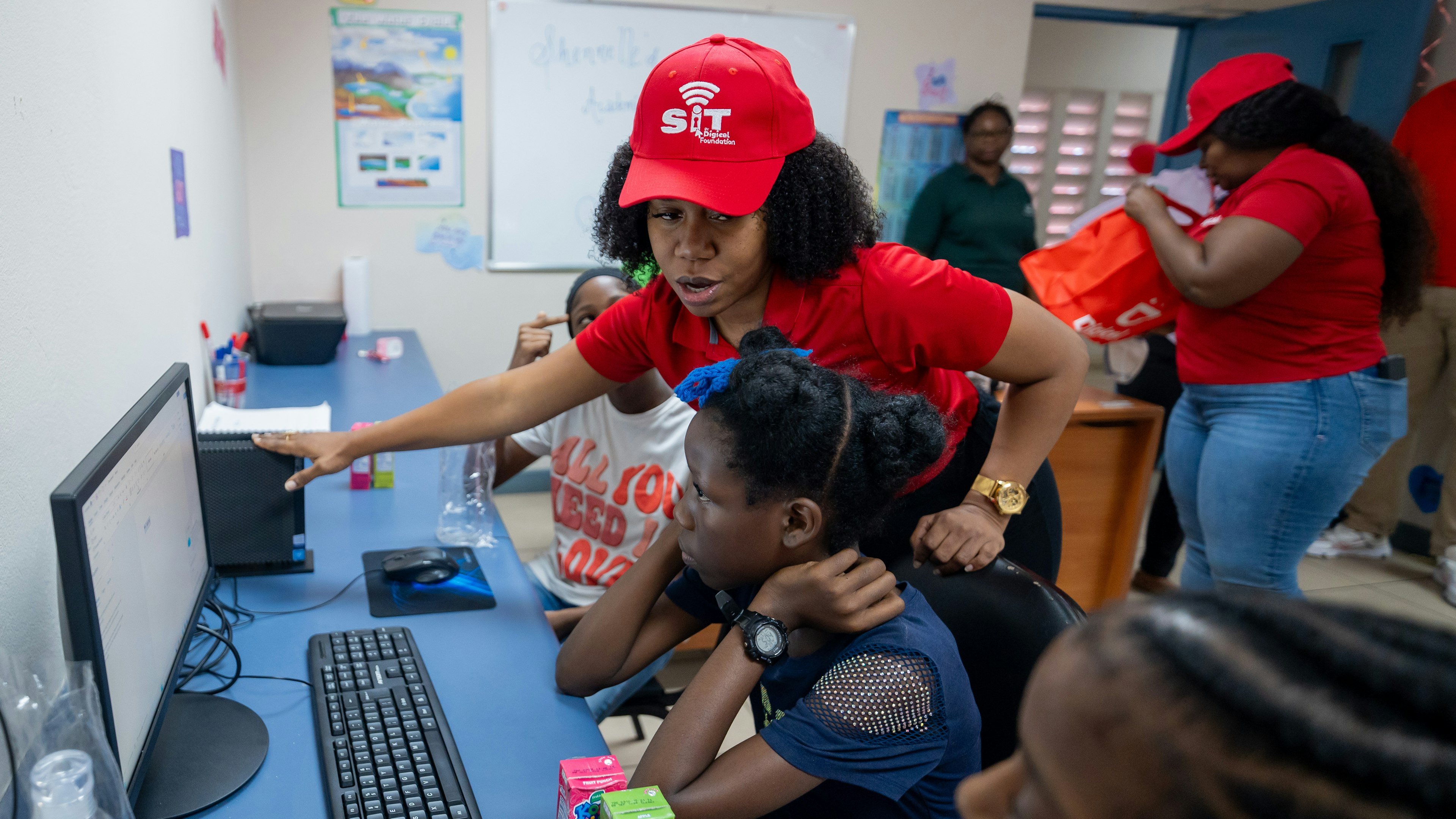 Digicel staff showing student a computer