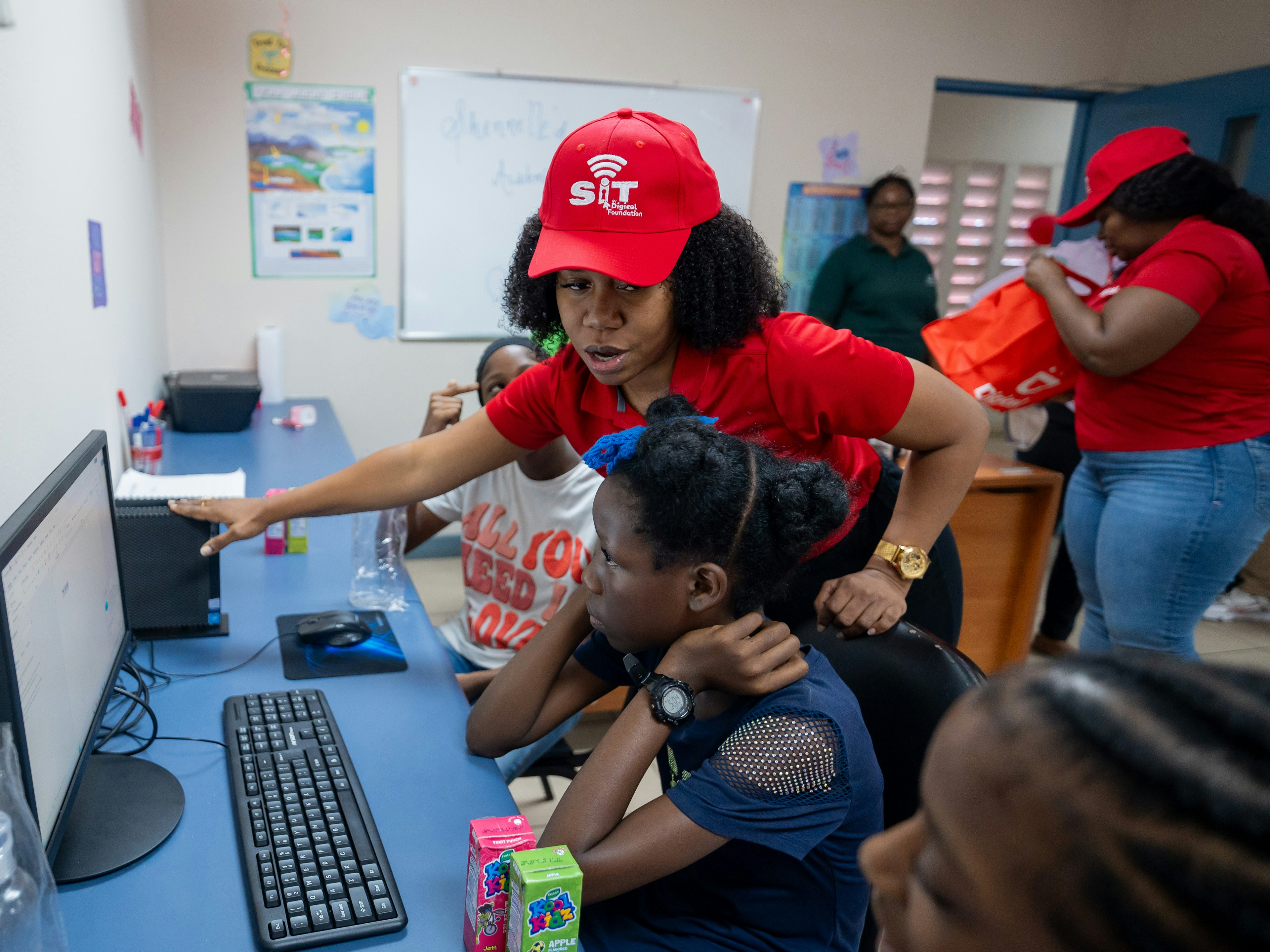 Digicel staff showing student a computer
