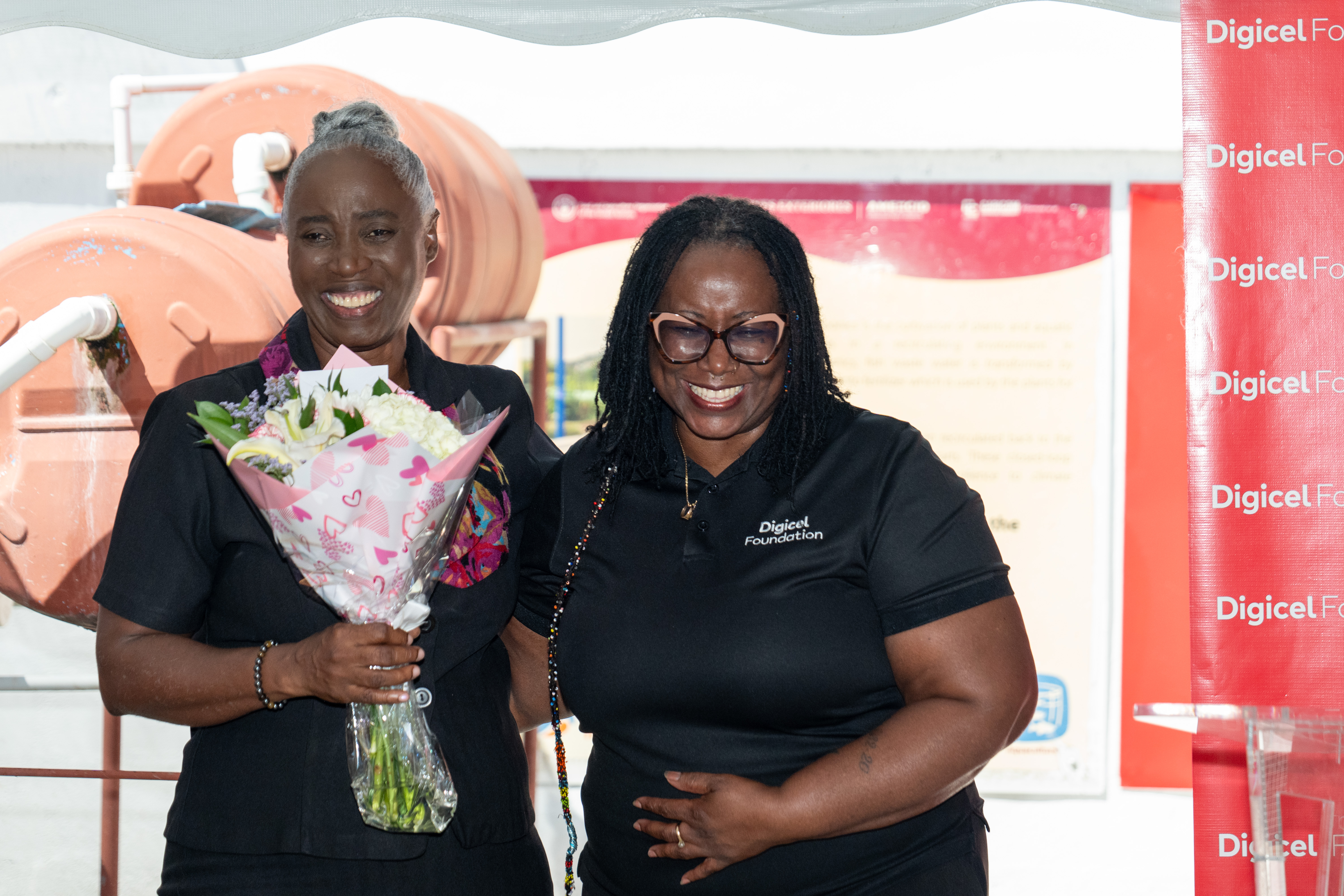 Digicel Foundation director presenting flowers to Mrs Pantin