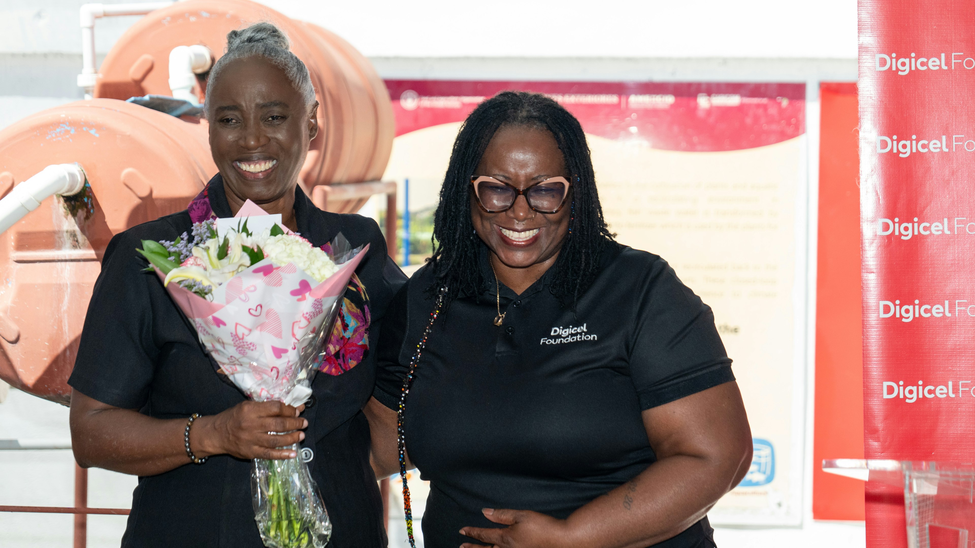 Digicel Foundation director presenting flowers to Mrs Pantin