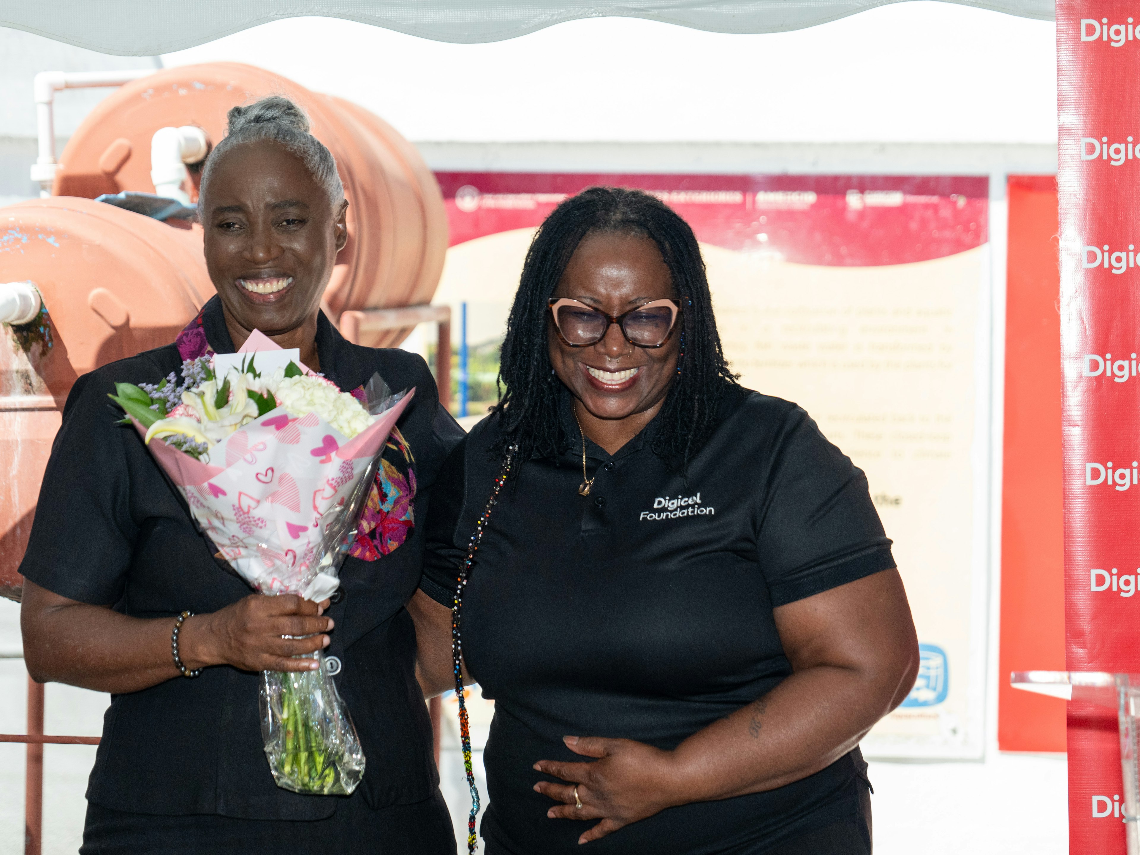 Digicel Foundation director presenting flowers to Mrs Pantin