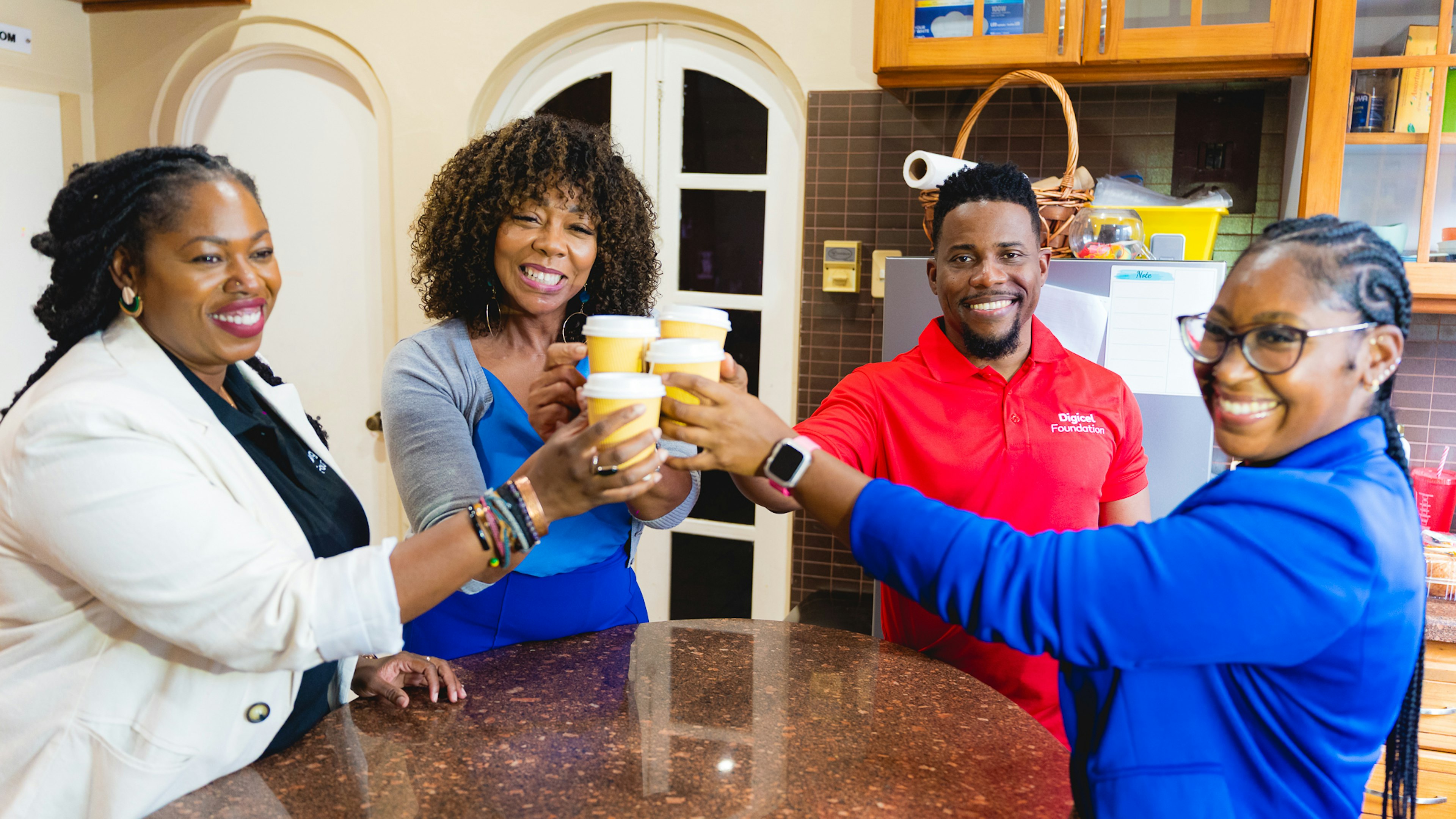 three Digicel Foundation staff and principal cheers at tea tasting