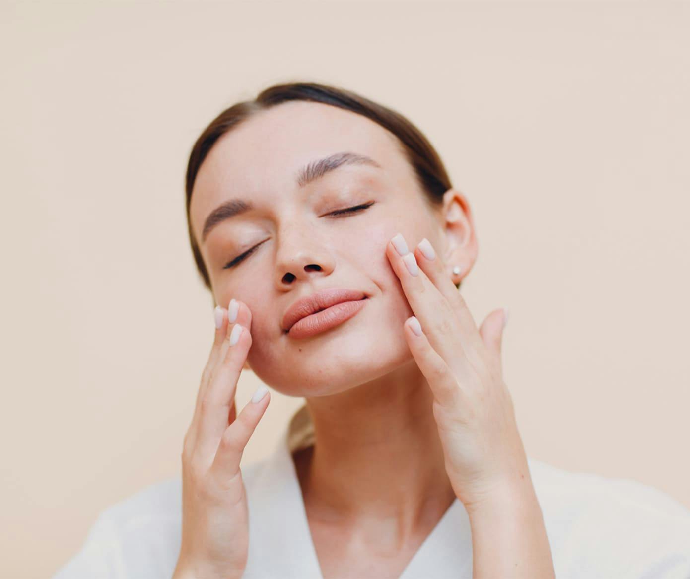 woman touching her face with her eyes closed