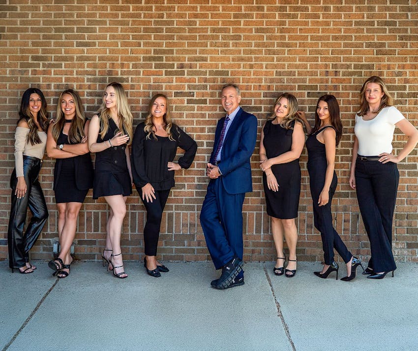 Dr. Berkowitz and his staff leaning against brick wall