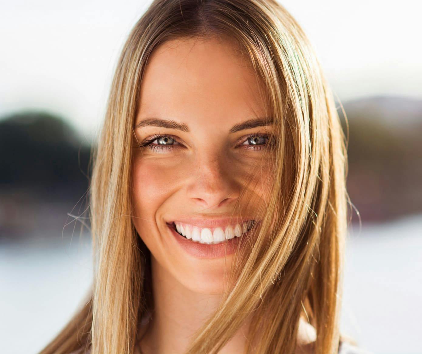 woman smiling forward with blonde straight hair