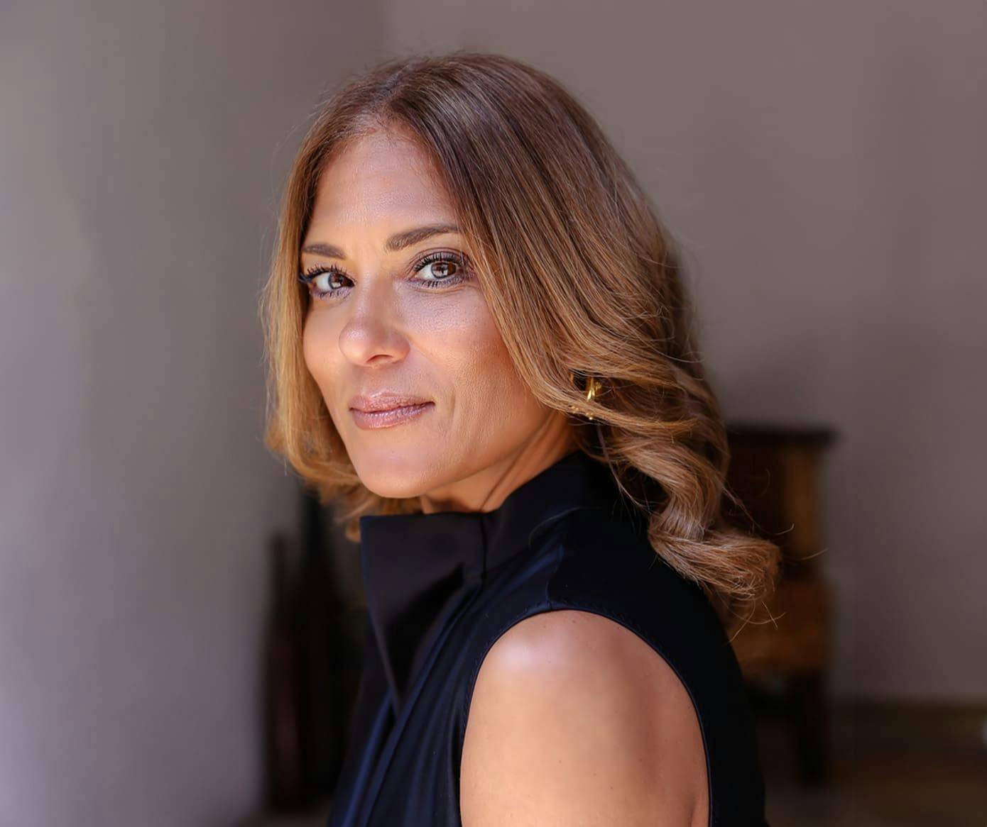 woman looking forward while facing her body to the left while wearing a black turtleneck