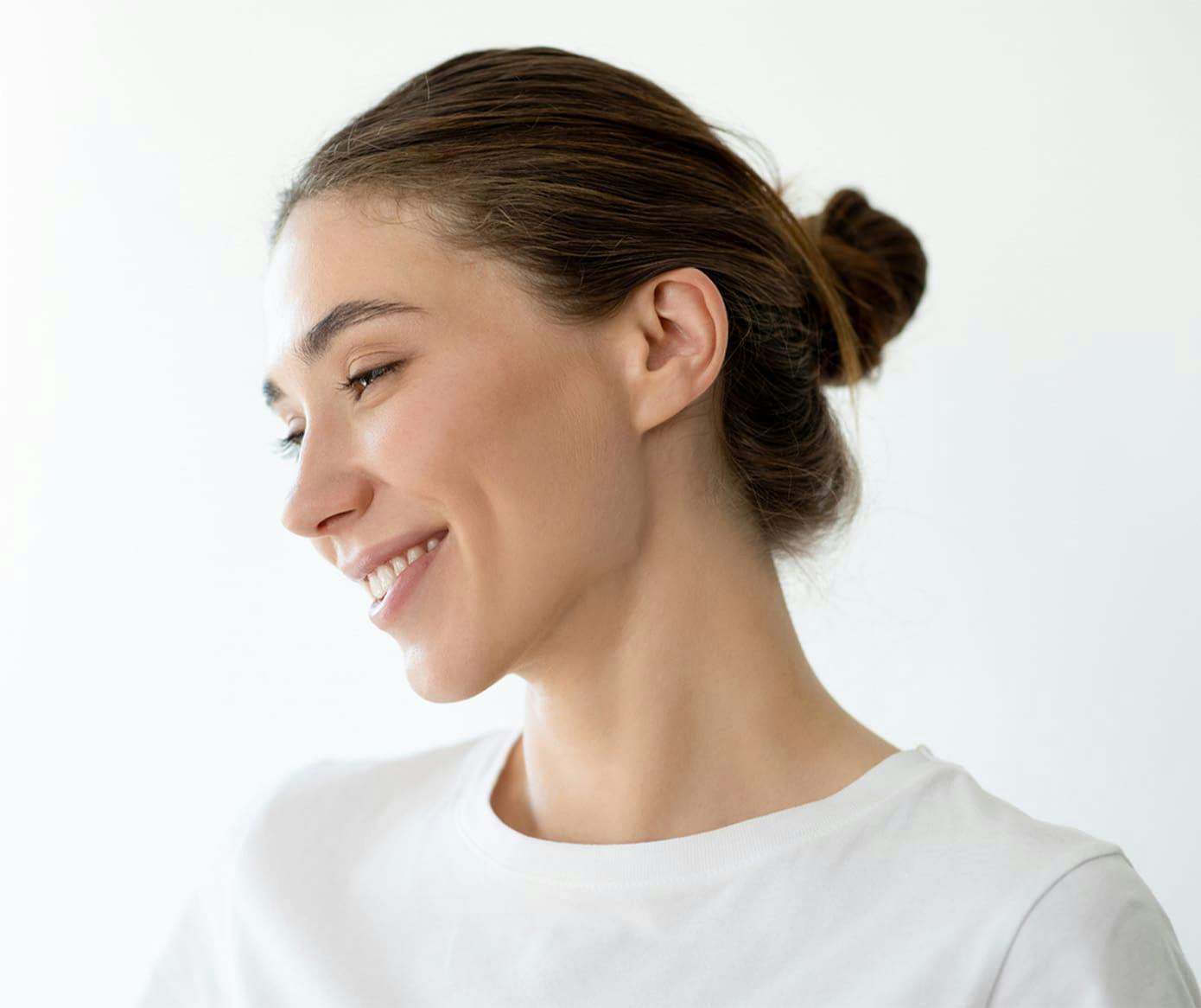 woman smiling with hair tied into a bun