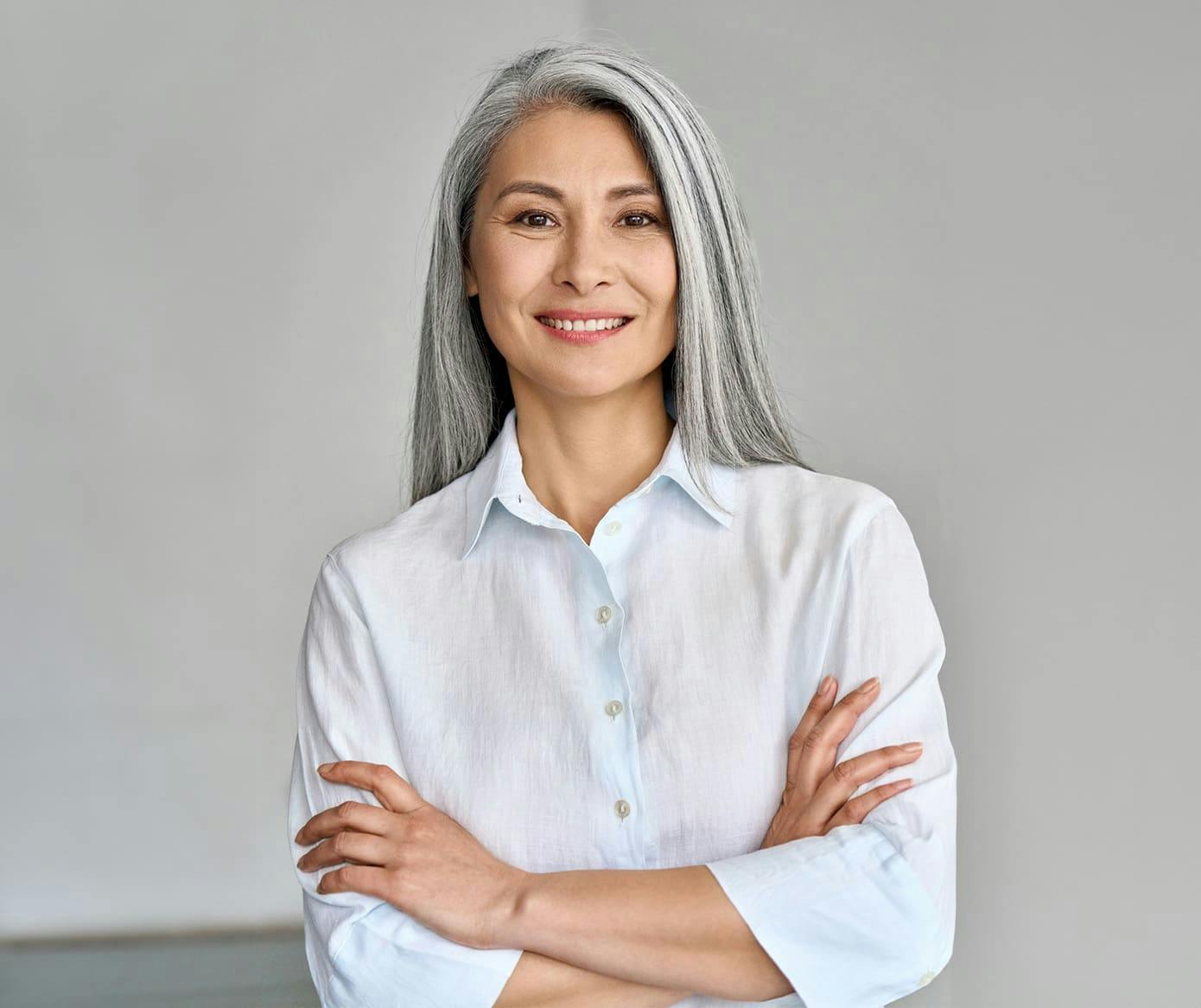 woman with gray hair crossing her arms and smiling