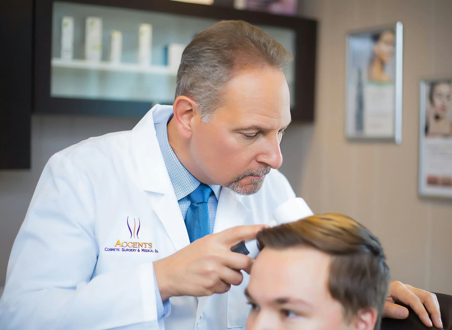 Dr. Berkowitz looking at male patients head