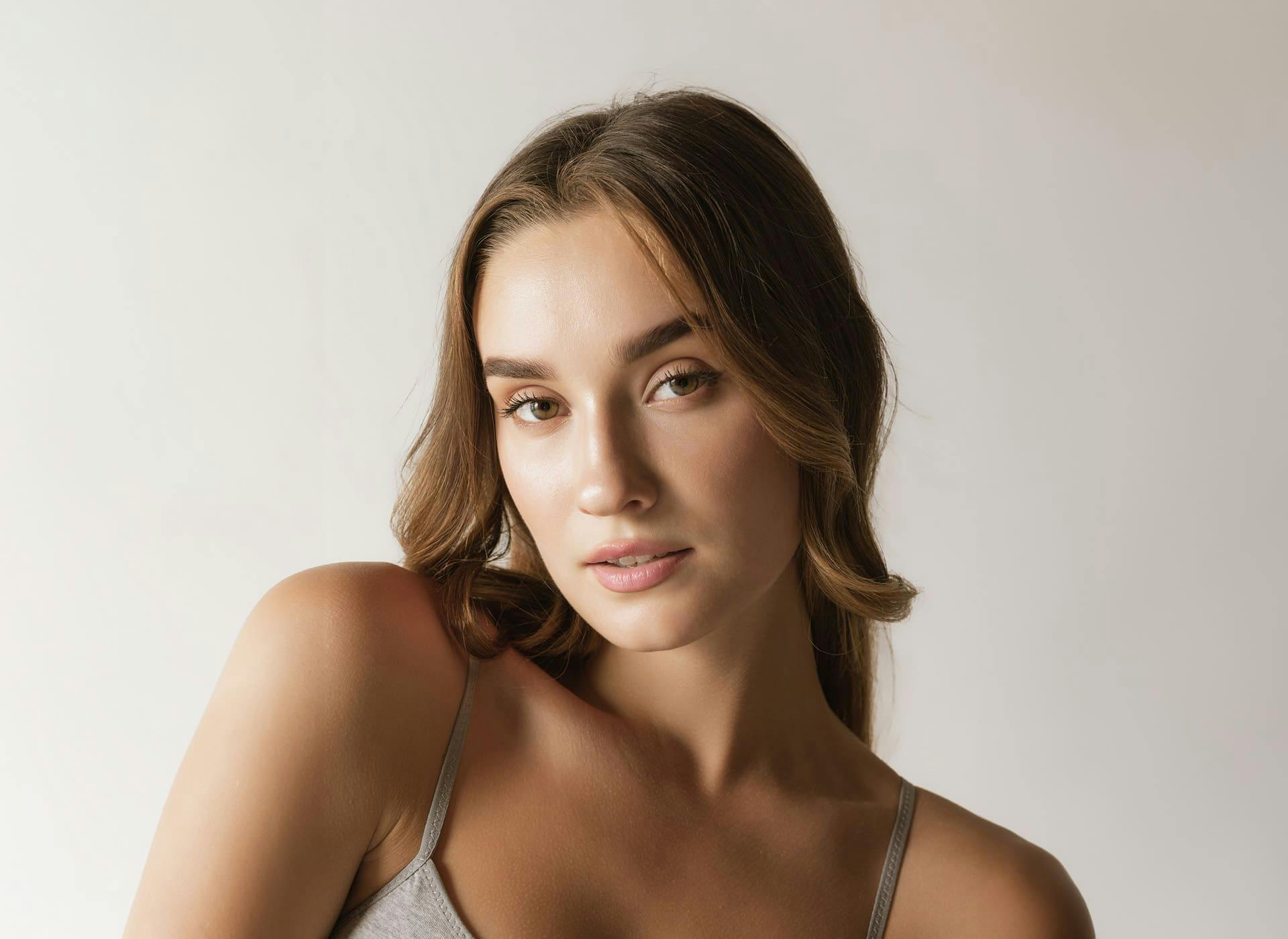 woman looking forward with her shoulder raised and head tilted