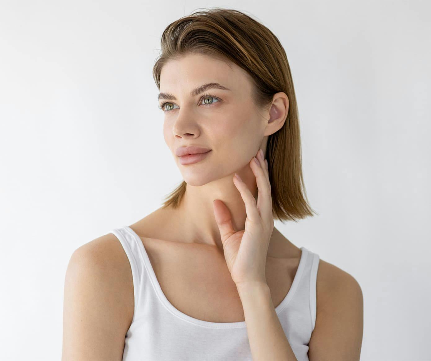 woman with short dirty blonde hair with her hand under her jaw