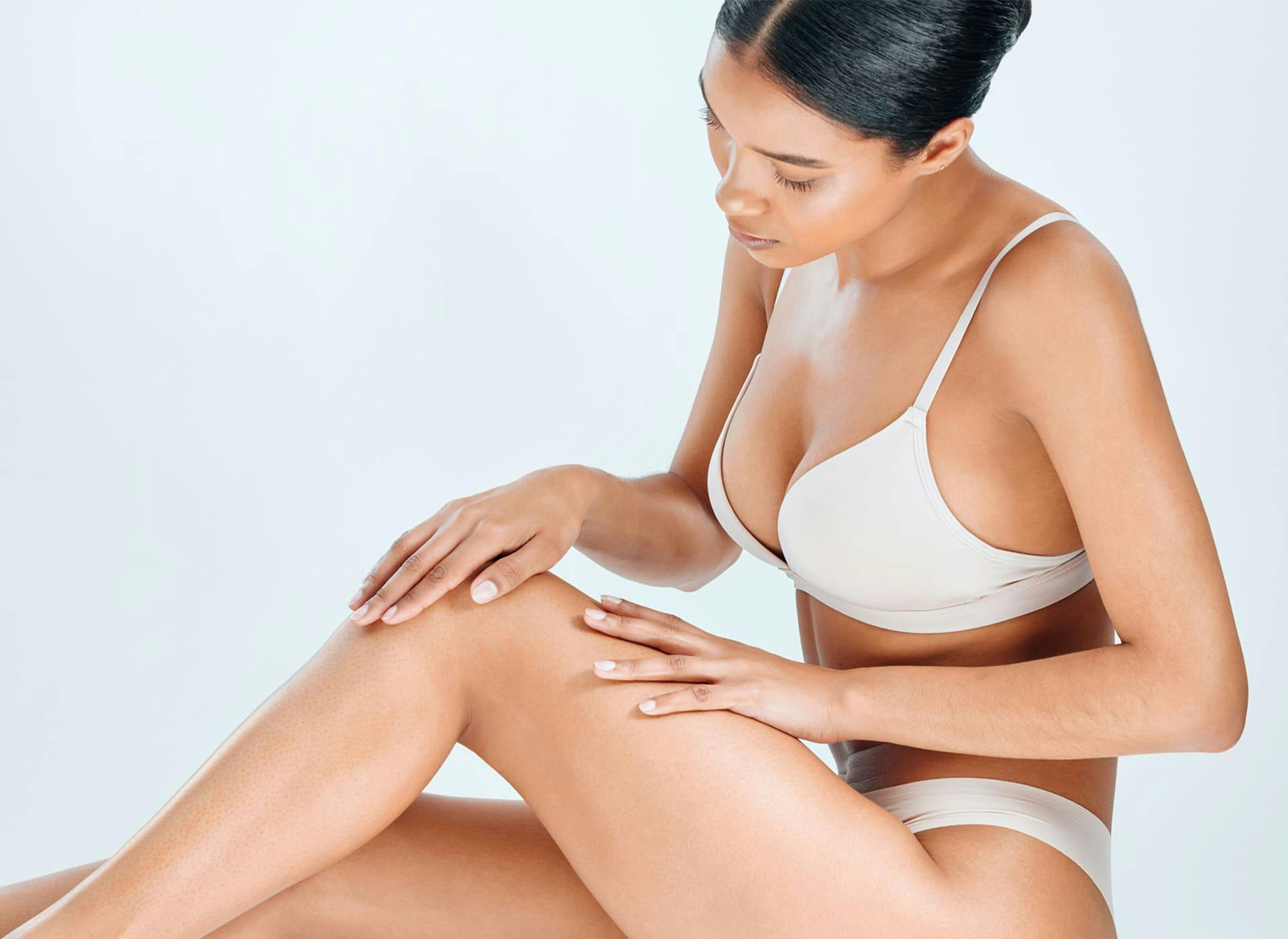 woman sitting down and looking at her leg