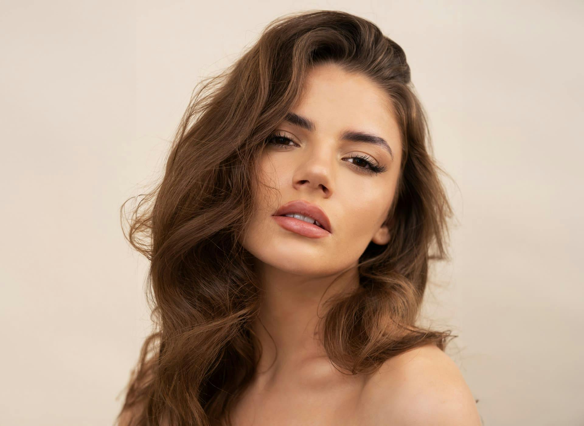 woman with wavy brunette hair looking forward