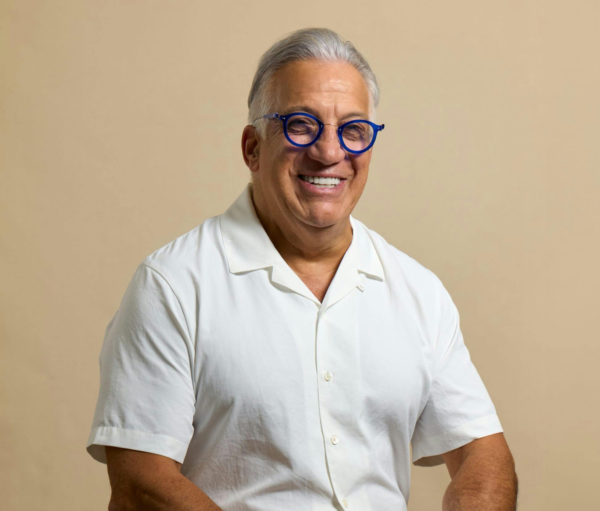 man smiling with blue glasses
