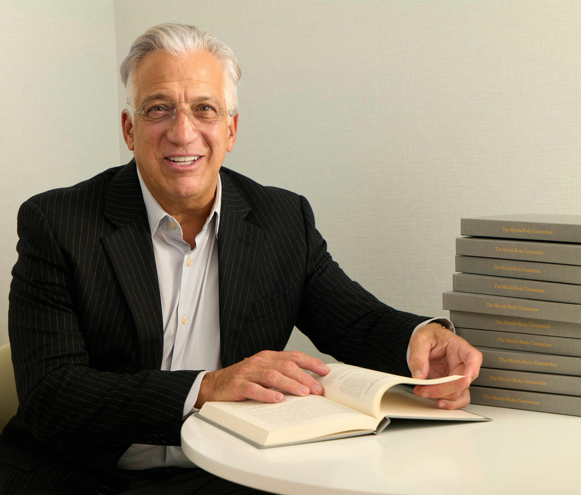 Gerry Curatola smiling with book open in front of him