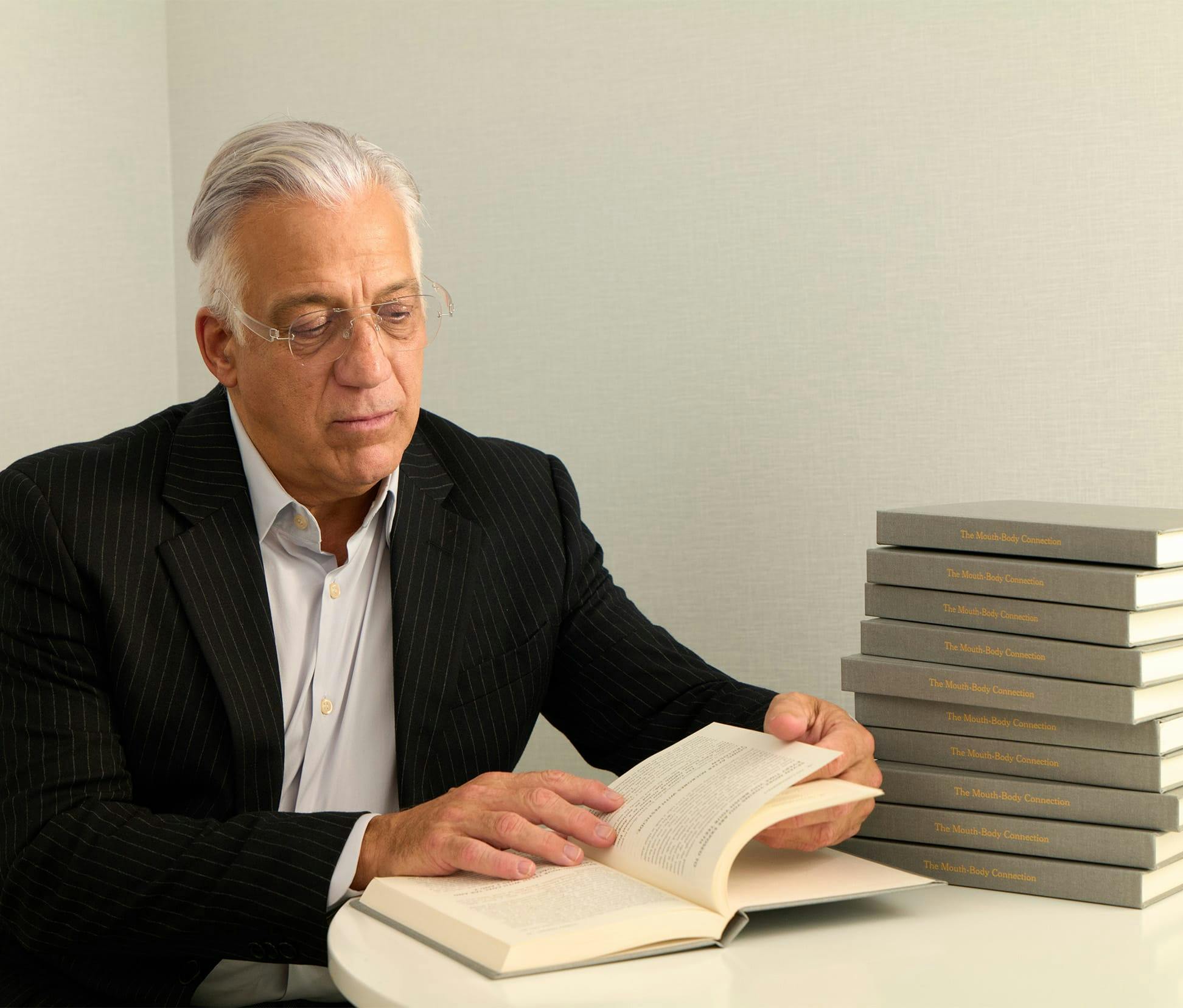 Gerry Curatola in suit reading a book