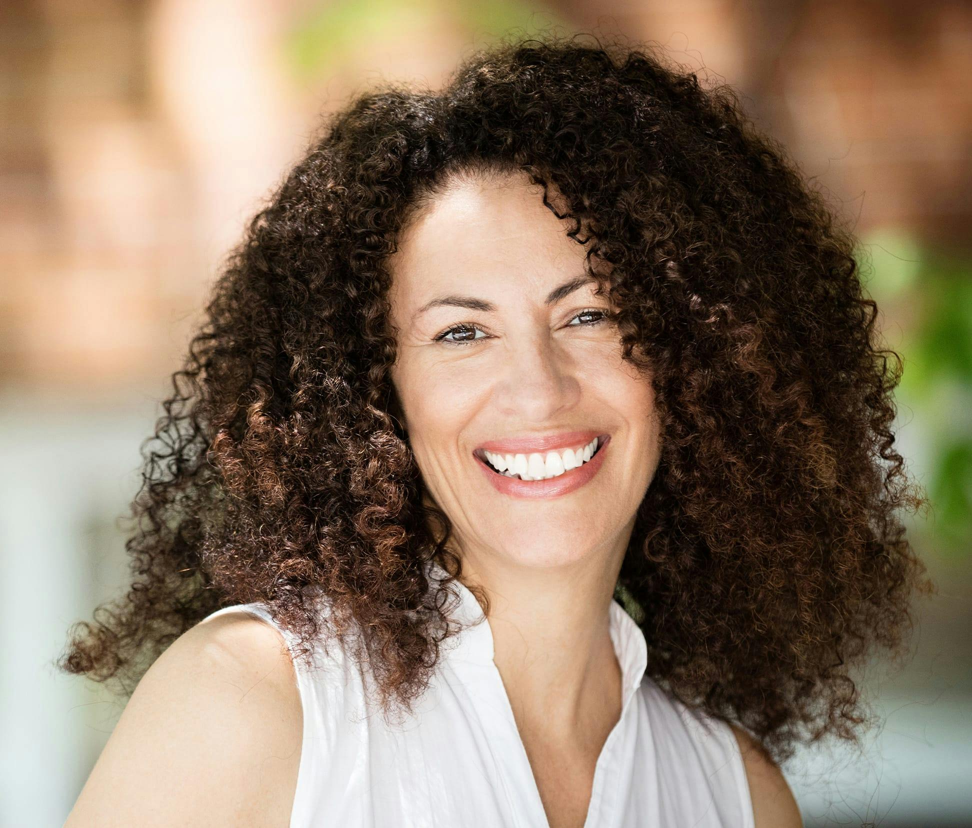 woman with big curly hair smiling
