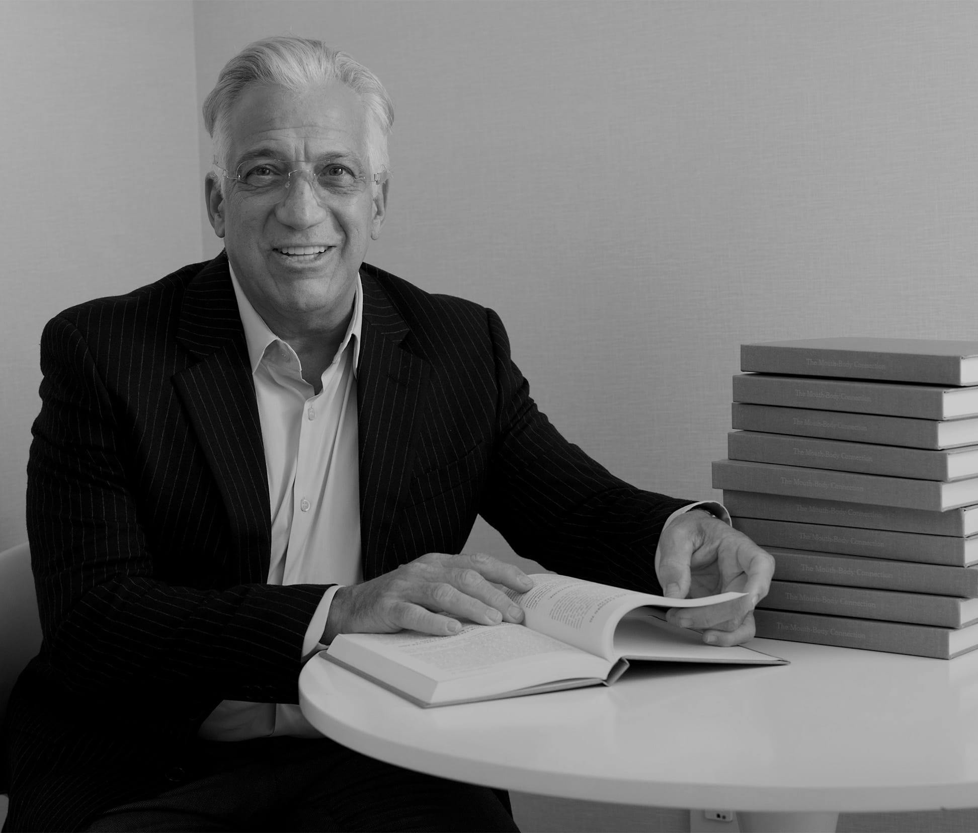 greyscale of Gerry sitting down with a book open