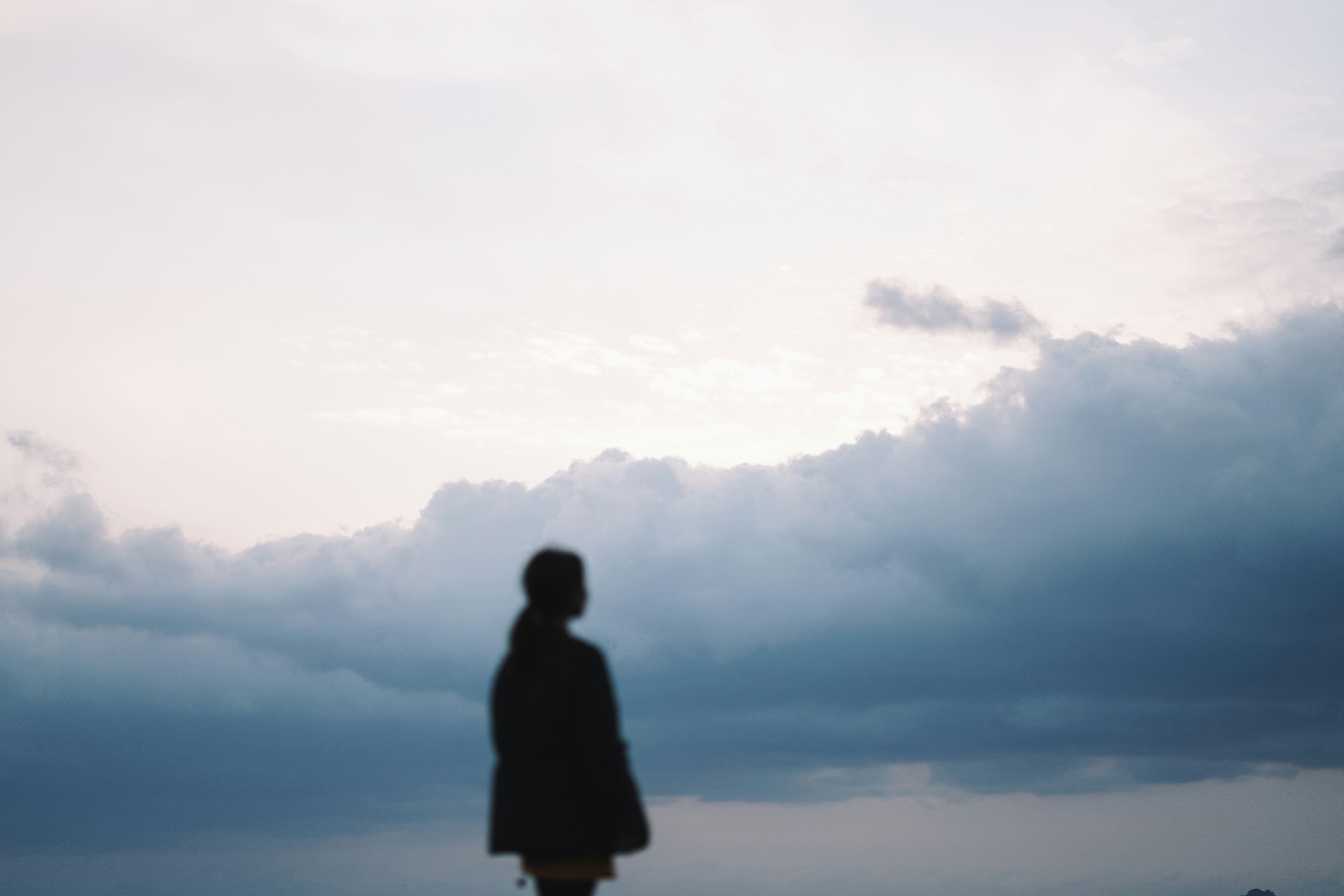 Woman standing infront of a sky with clouds