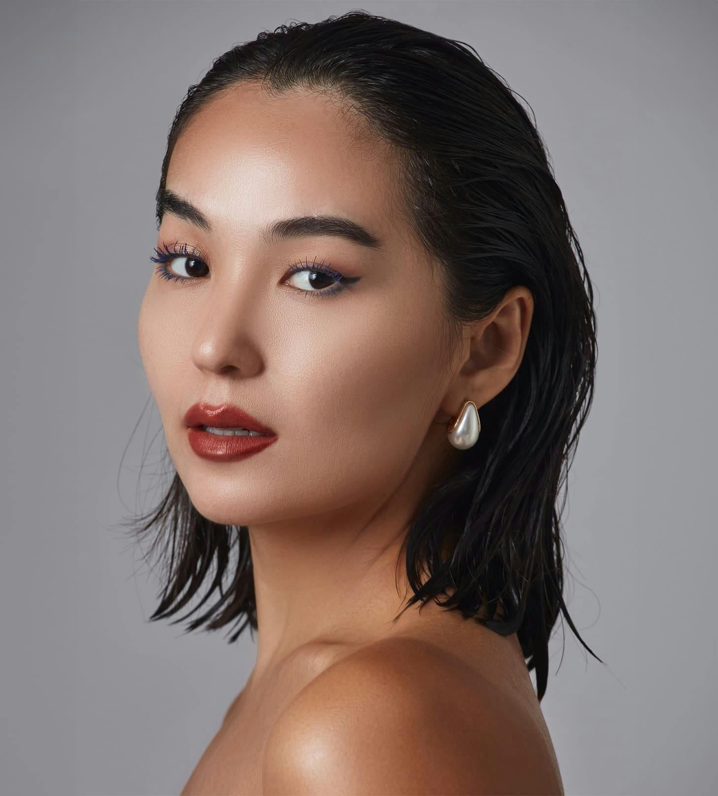 woman with slick back hair and red lips