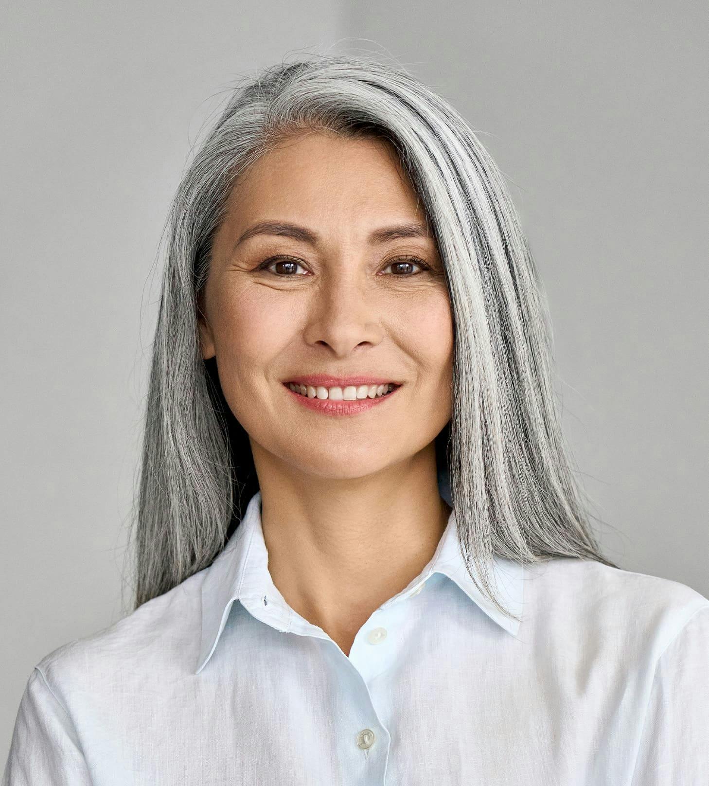 woman with straight gray hair smiling