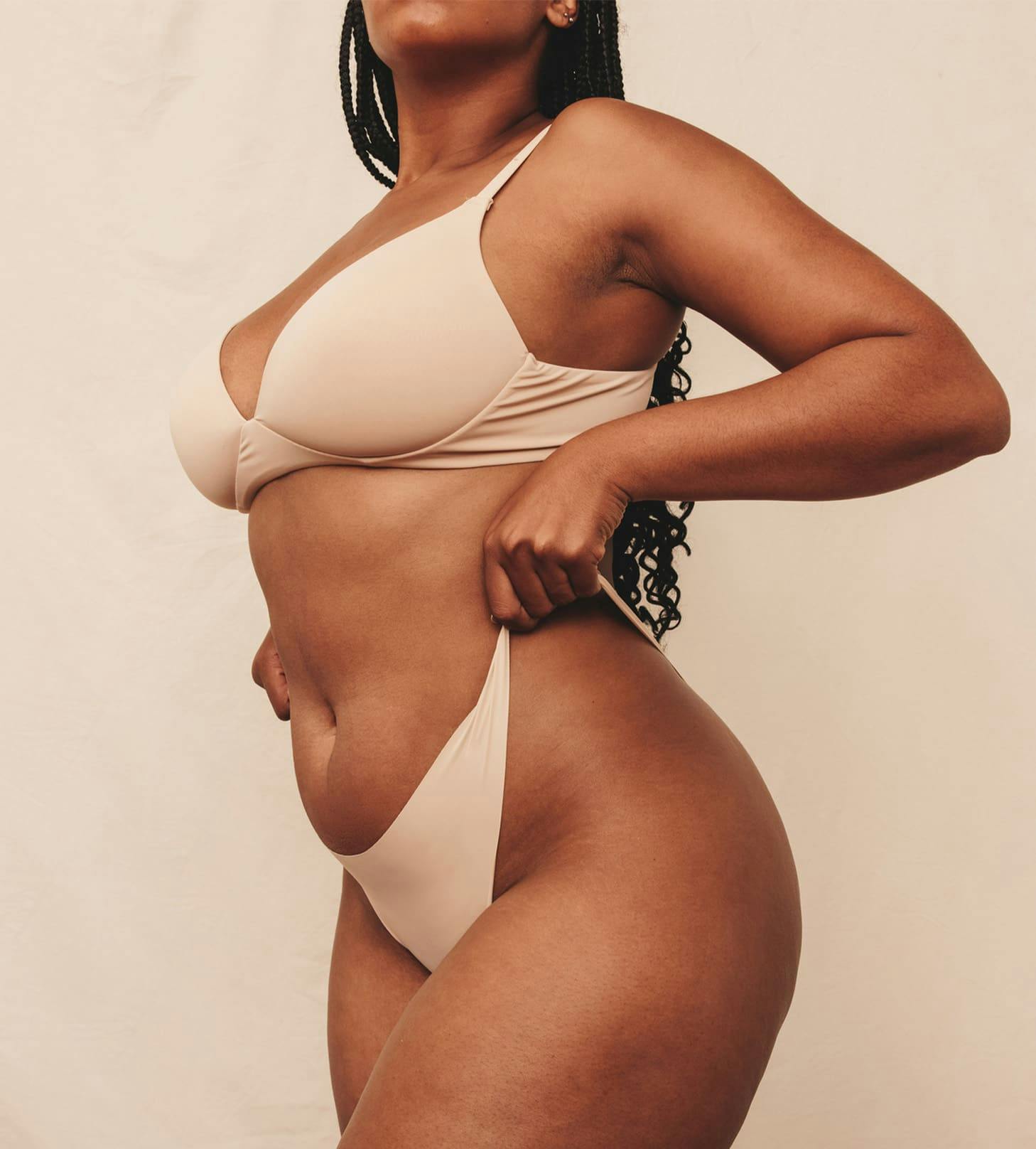 woman pulling up the sides of her beige underwear