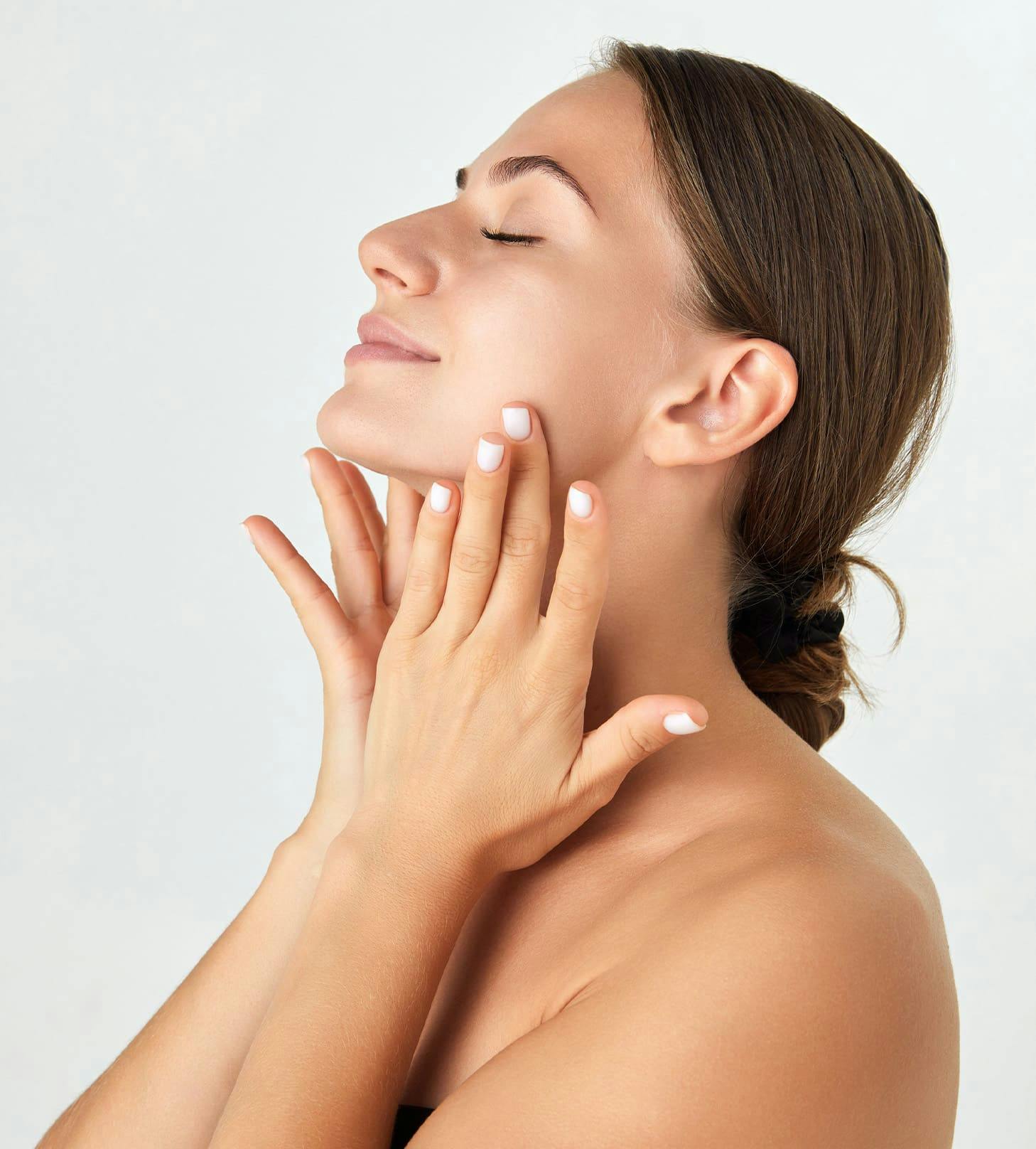 woman with her hands under her chin with her head tilted up