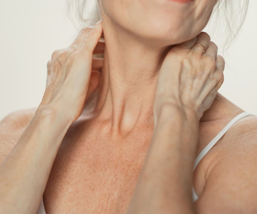 close up on woman's neck with her hands on either side