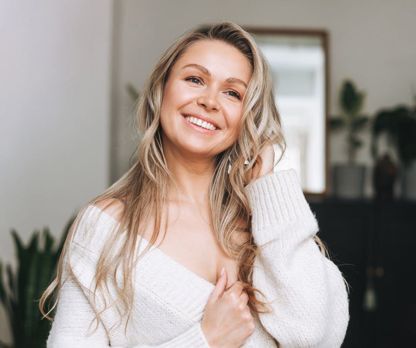 woman smiling in white sweater