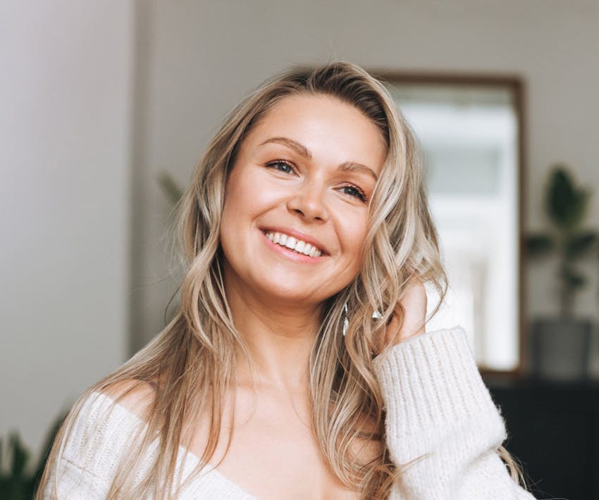 woman smiling with her hand in her hair