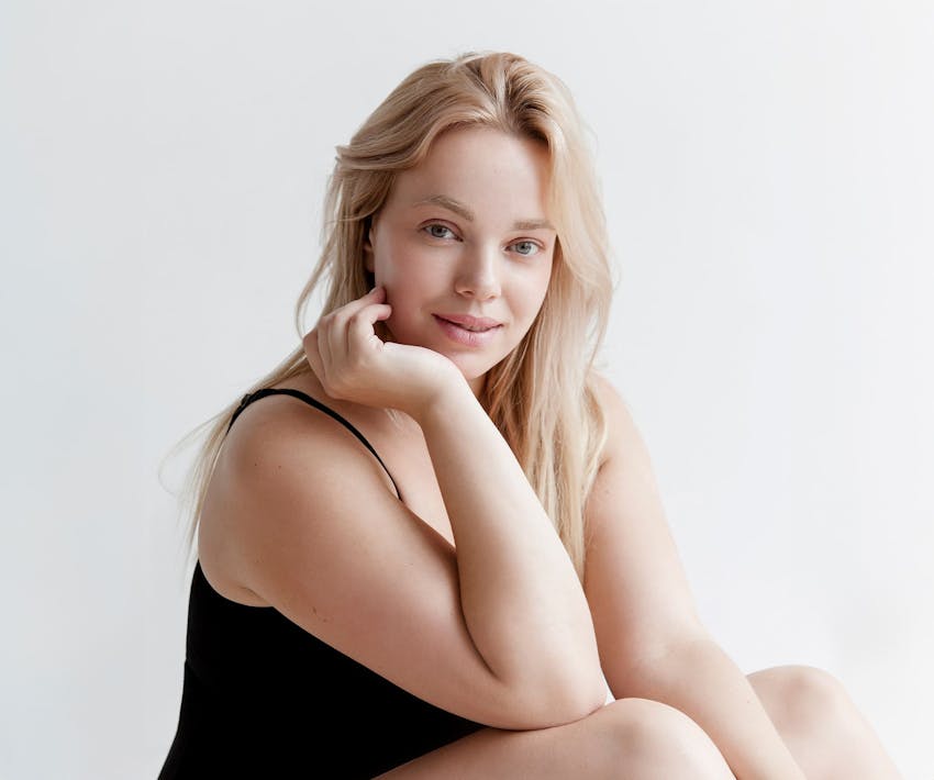 blonde woman resting her chin in her palm