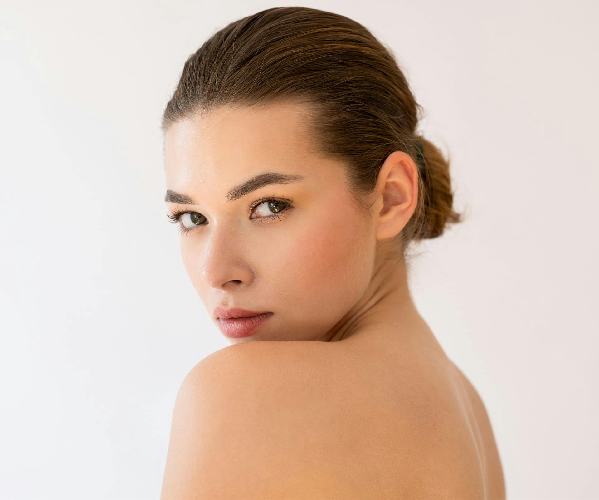 woman looking over her shoulder with a low bun