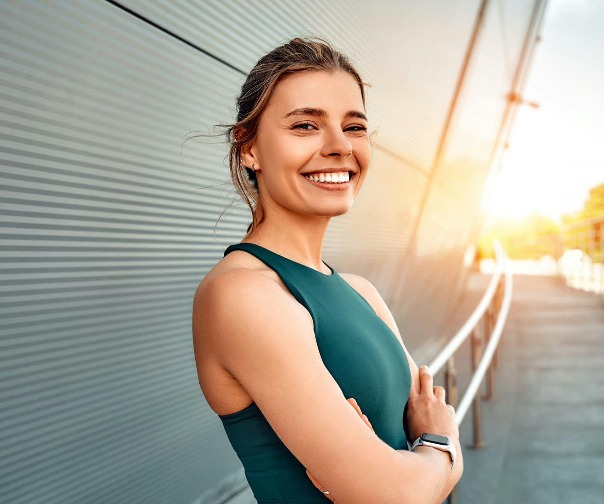 woman outside with her arms crossed leaning against railing