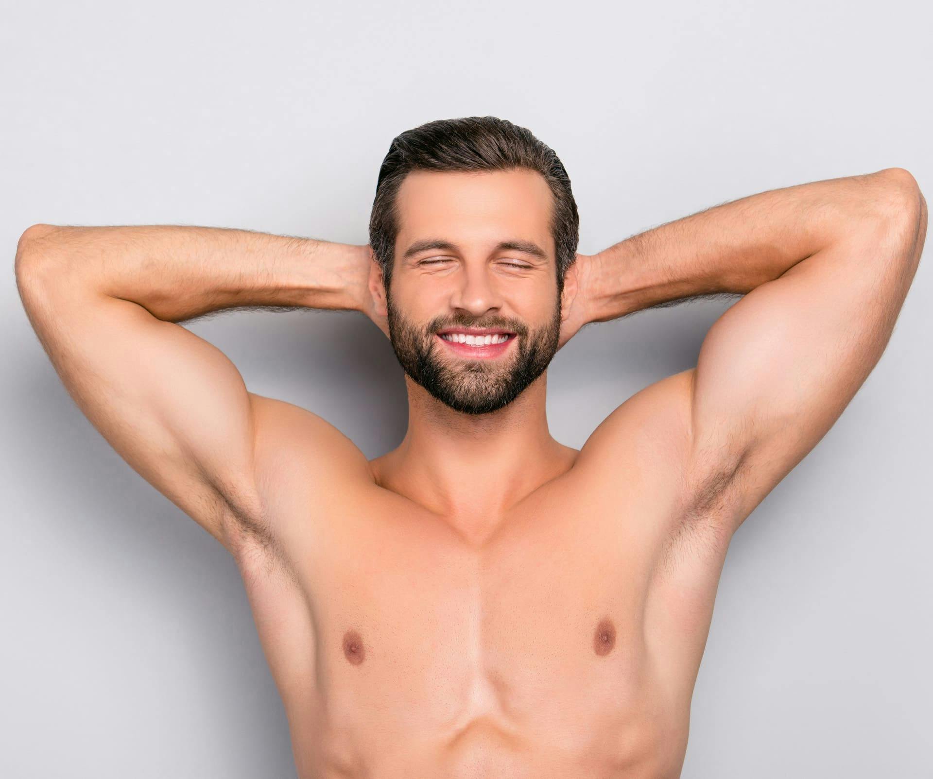 man smiling with his eyes closed and his hands behind his head