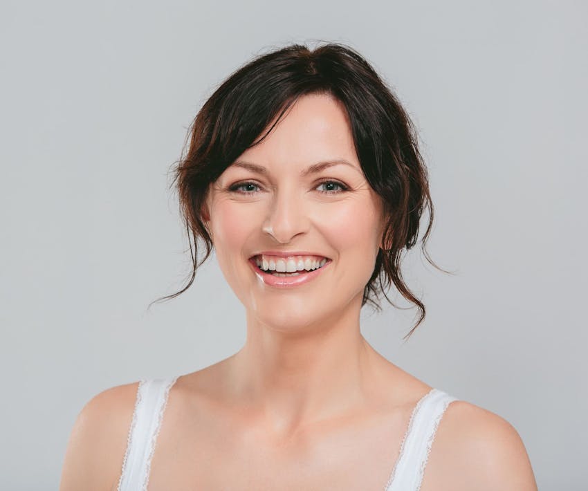 woman smiling forward in white tanktop