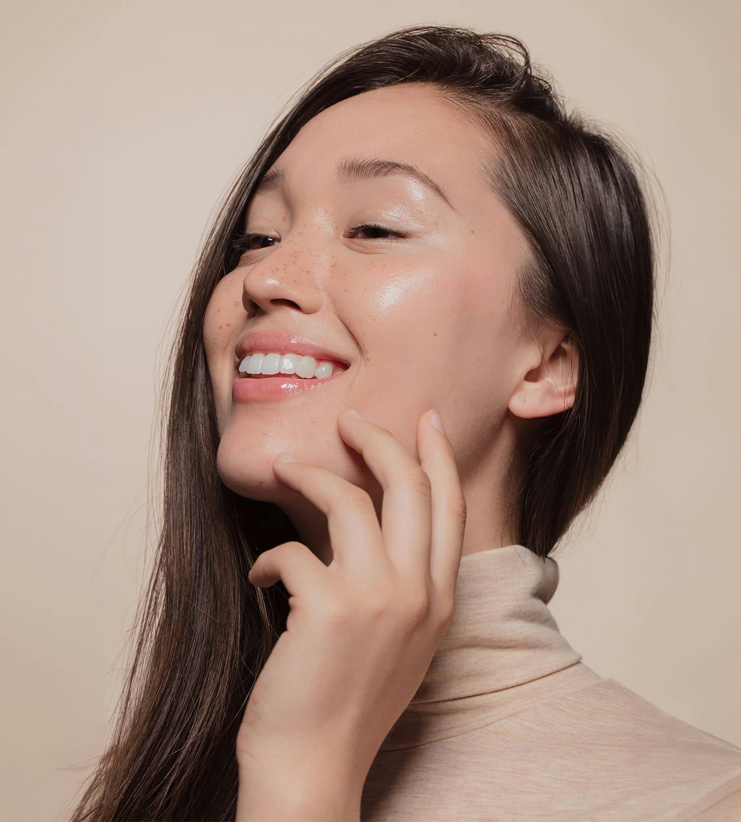 woman smiling with her fingers on her jaw