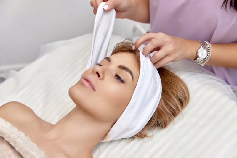 woman laying down getting a spa headband on