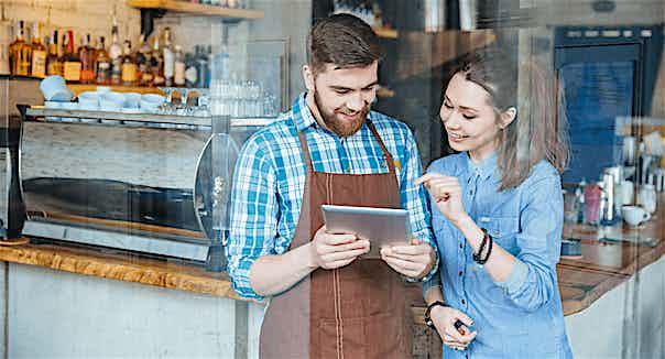 Lokalbesitzer mit Tablet und Kassensystem