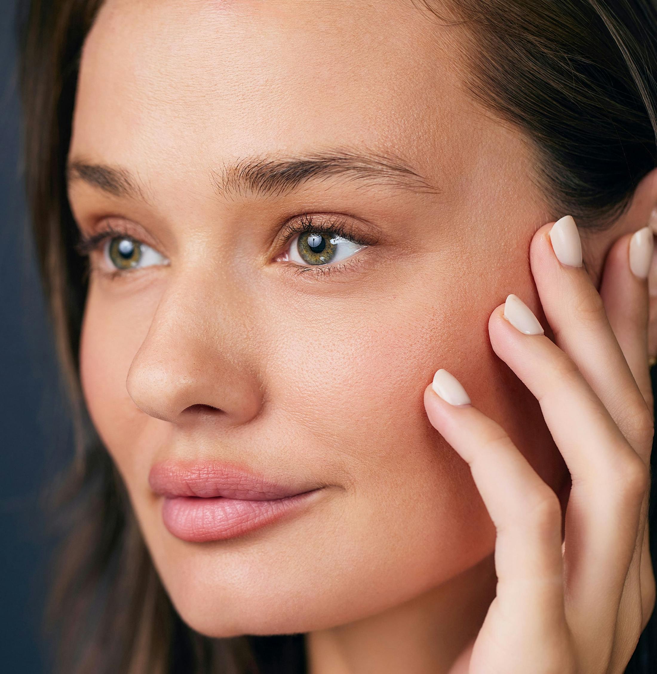 Woman smiling with her hand on her cheek