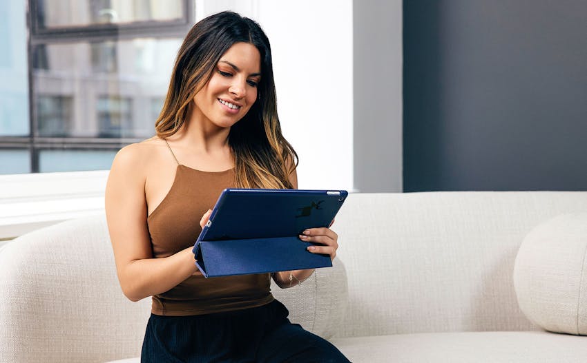 Woman smiling and looking at a tablet