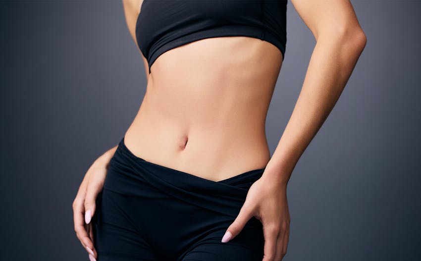 close up of a woman's abdomen in black bra and shorts