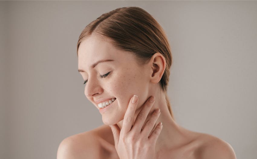 woman with hand rested on chin and hair tied back