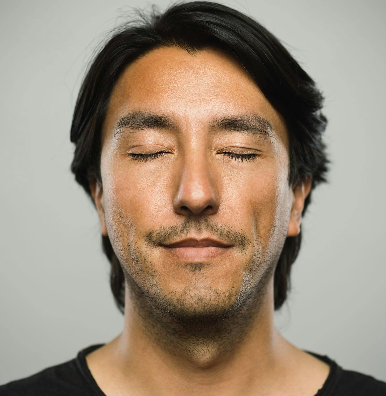 man in black shirt with his eyes closed and smiling