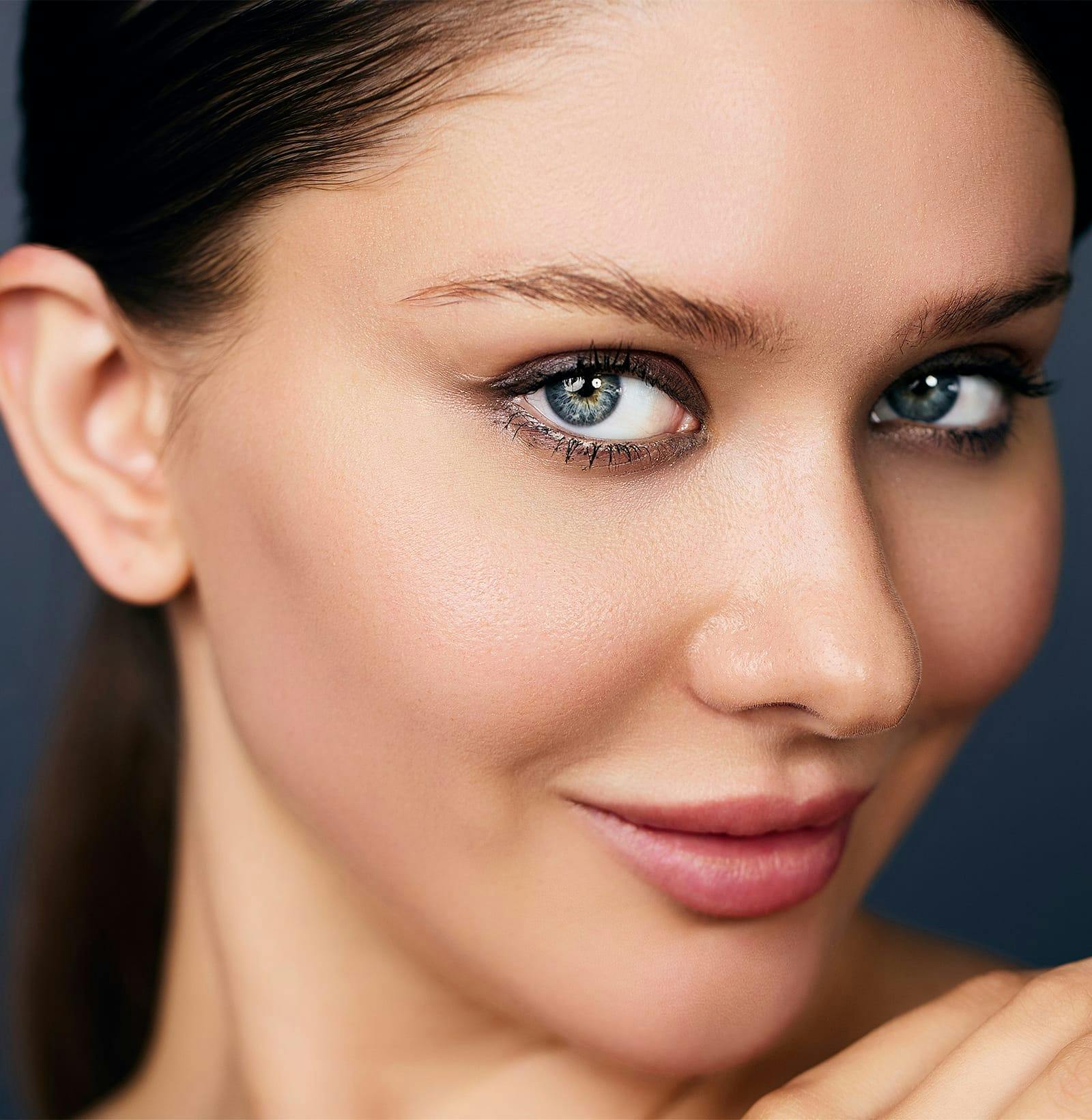 close up of woman's face with hair back in a ponytail