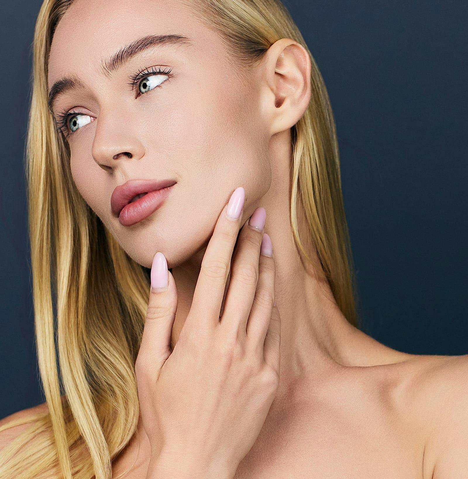 woman looking off to the side touching her jaw