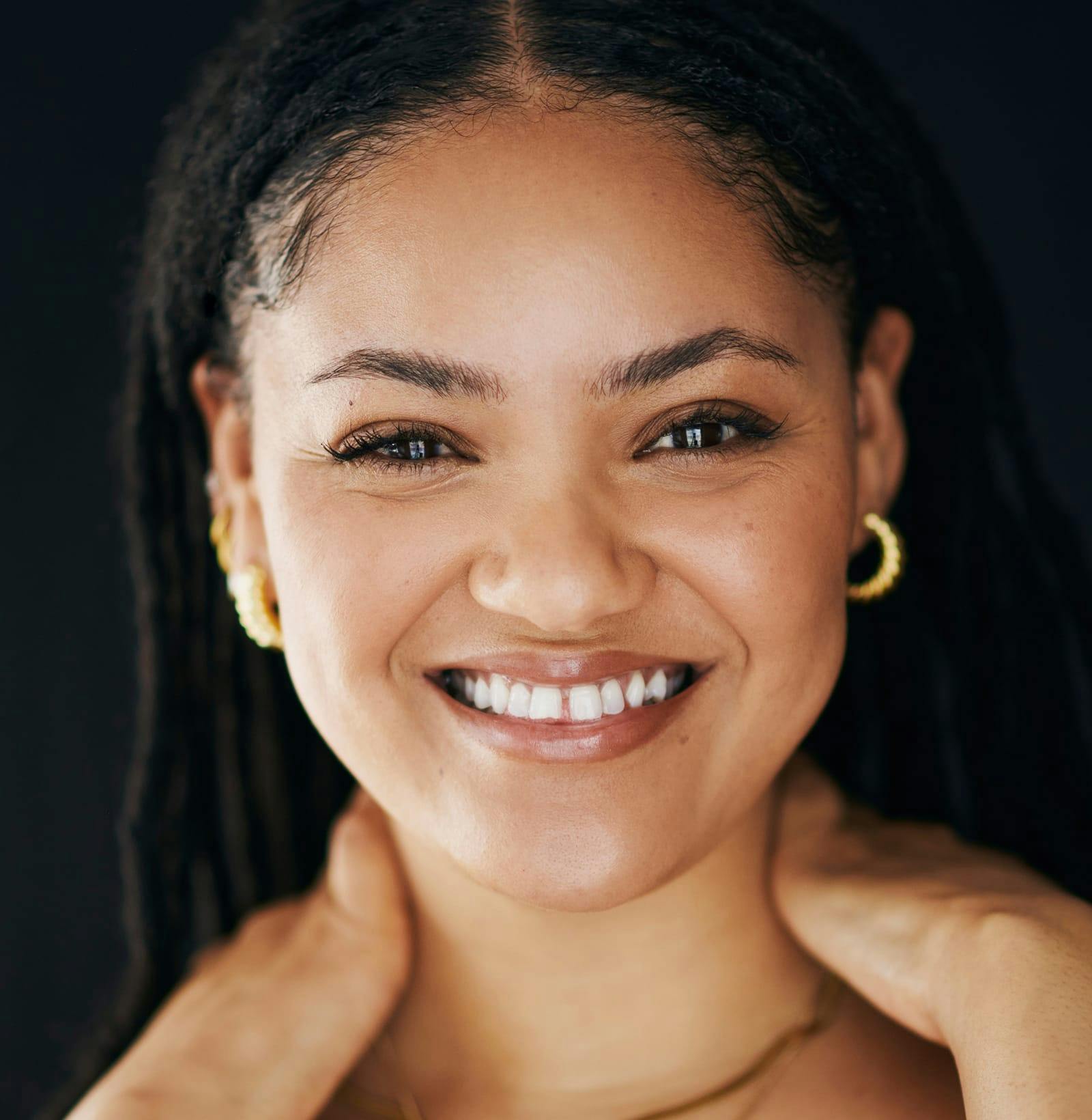 woman with dreads and hands on her shoulders