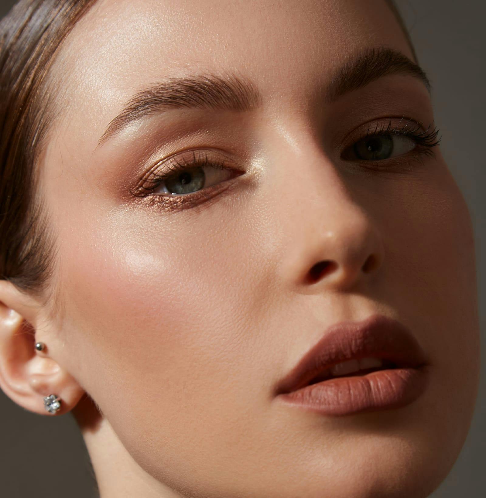 close up of woman's face with her hair tied back