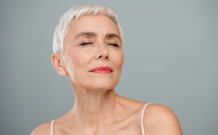 woman with short white hair in white camisole