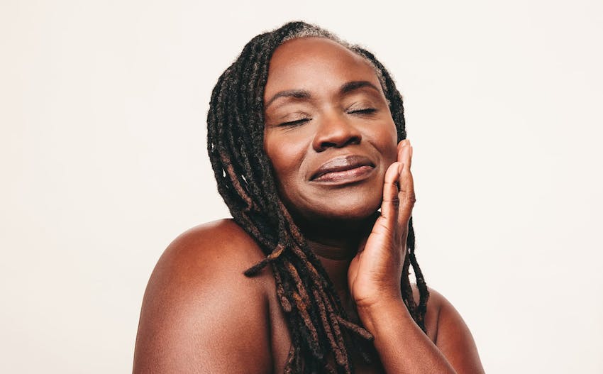 woman with dreads touching her lower face