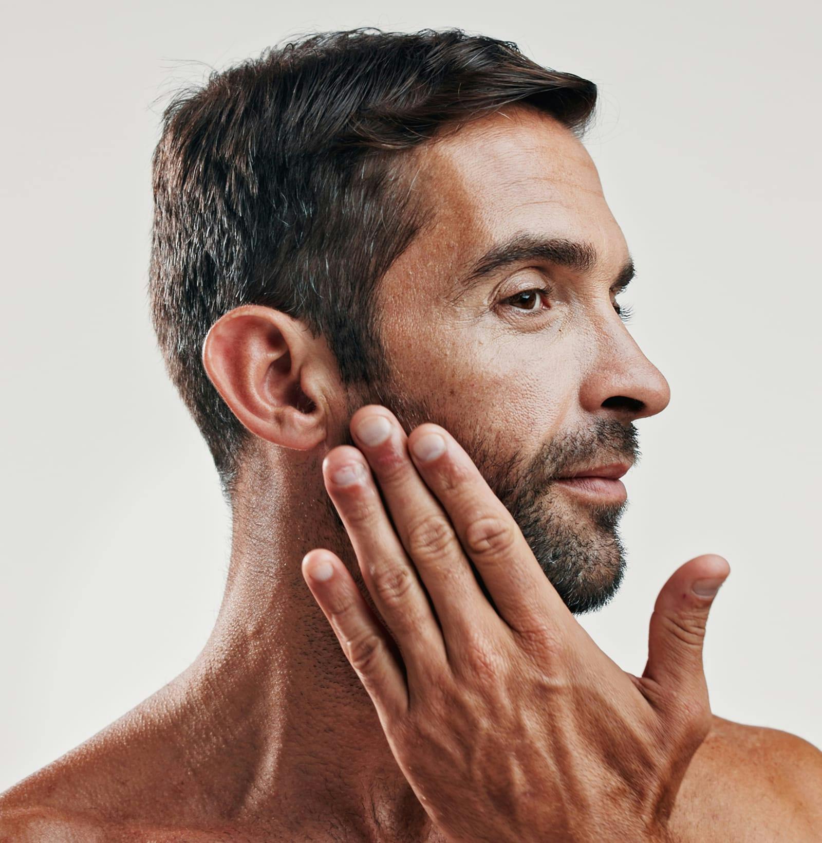 bearded man touching his jaw